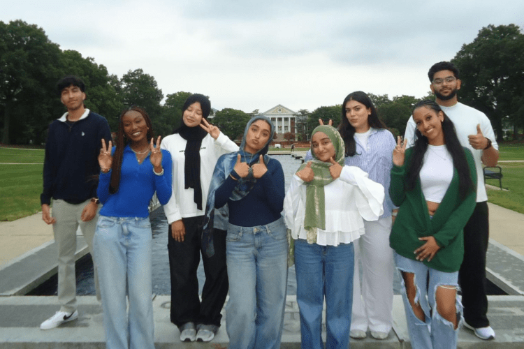 student group of young men and women, some wearing headscarfs smile to camera at UMD