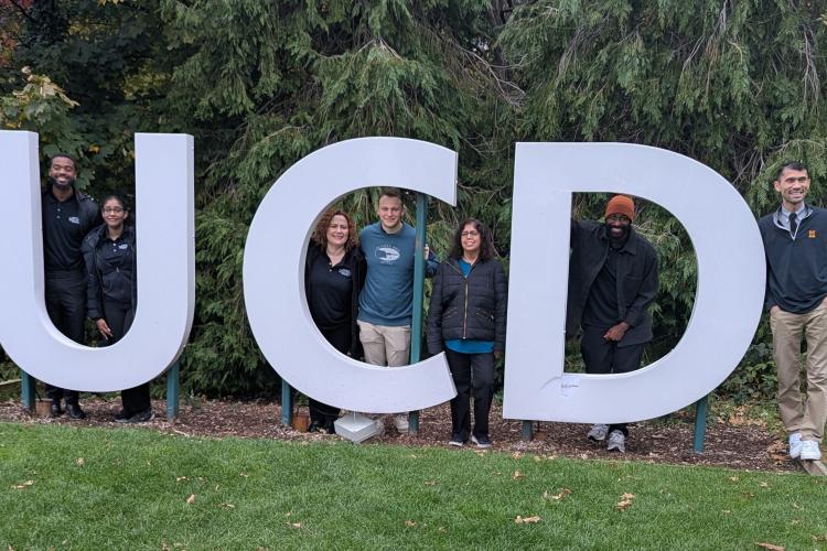 Students pose with large letters: UCD in Dublin 