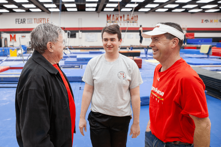 Grandfather, father and son laugh together at the Gymkana gym