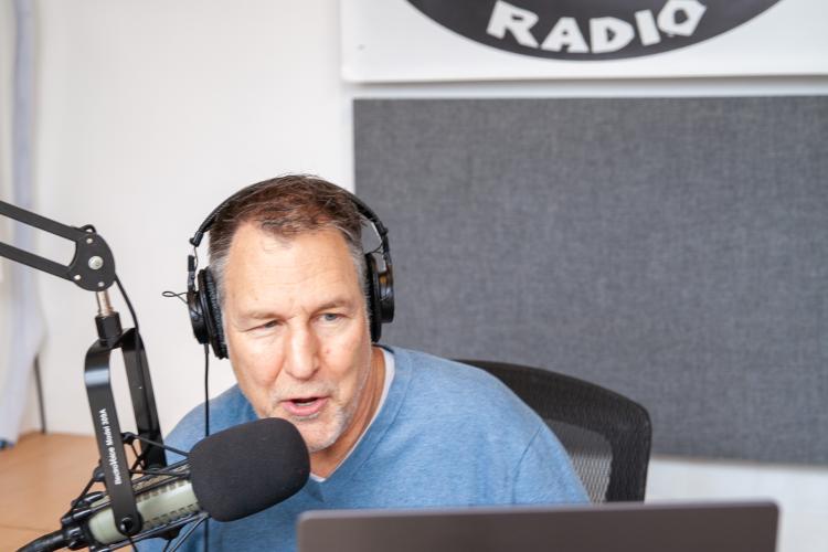 Professor speaks into mic at local radio station WOWD