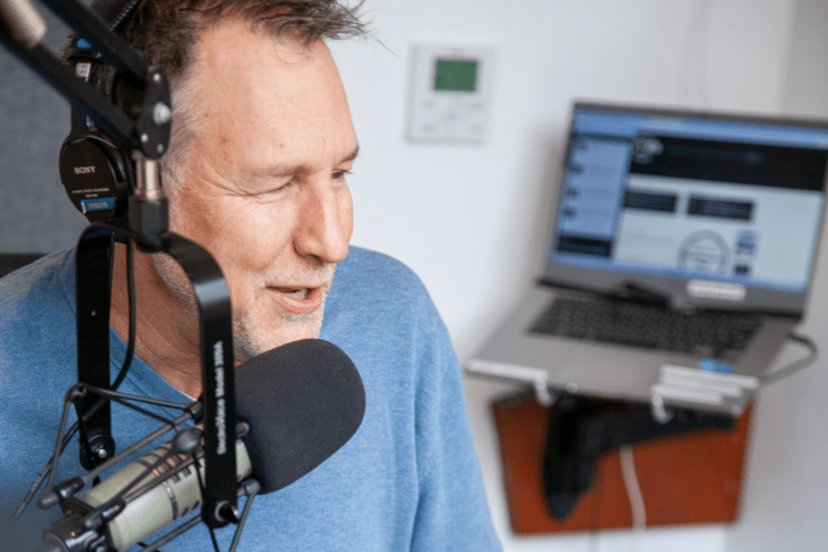 Professor and DJ speaks into the mic at a radio