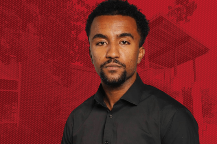 Black male grad student in dark grey shirt with goatee in front of red graphic background