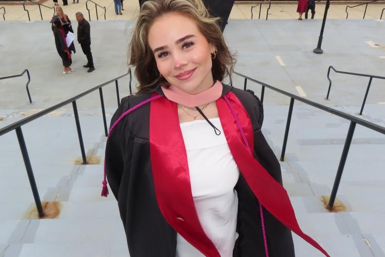 woman in graduation attire smiling