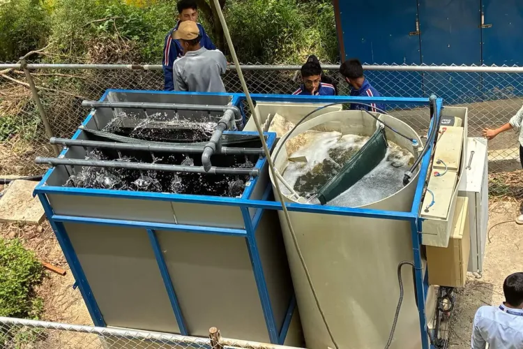 The machine that turns waste water into usable water, with men in same blue shirt beside it