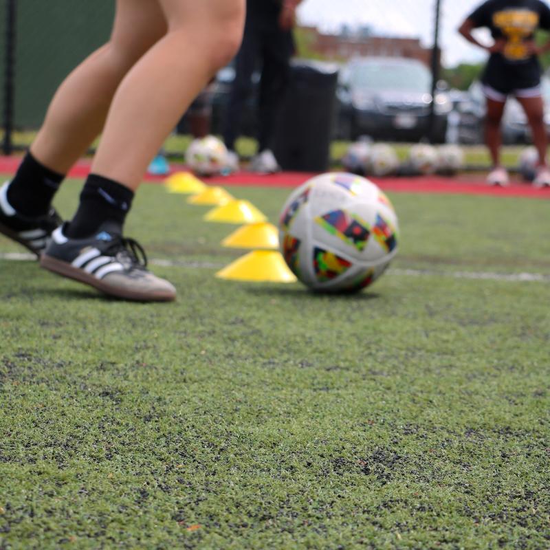 soccer ball by drill cones and a player about to kick