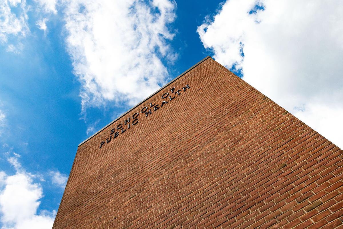 Looking up at the School of Public Health Building with blue sky and clouds above