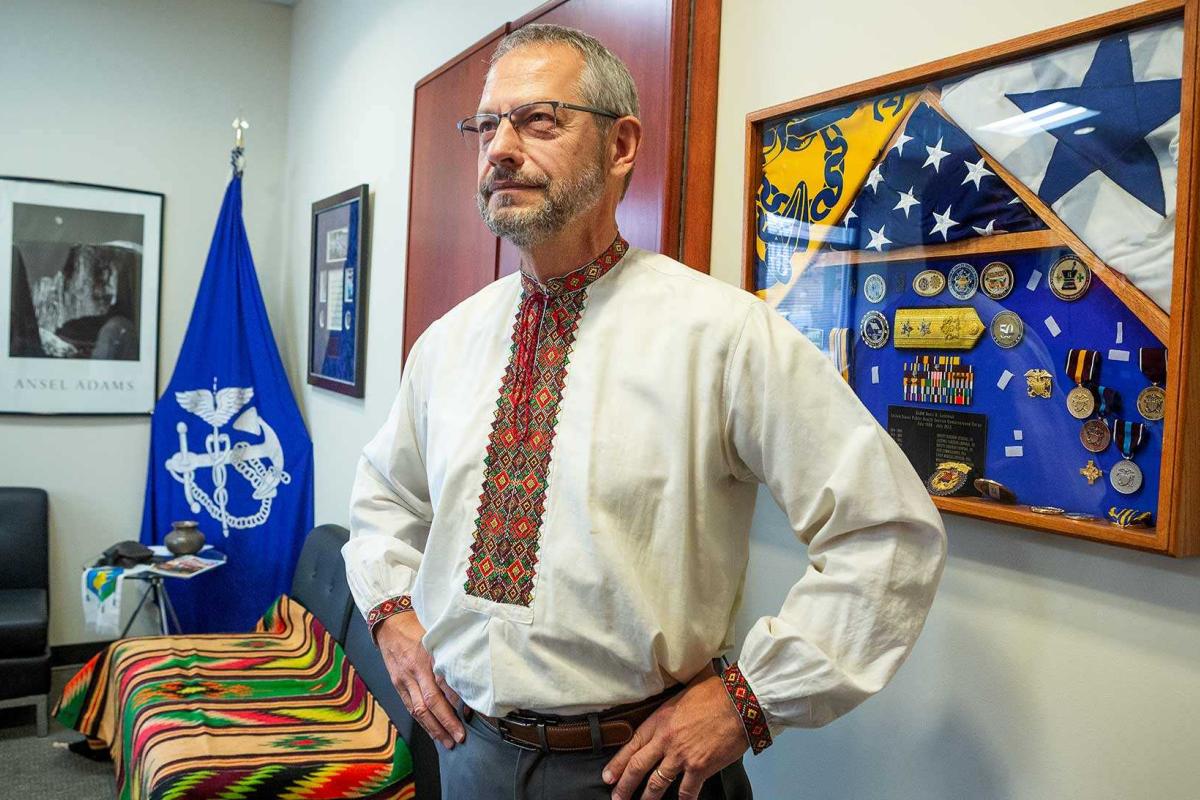 SPH Dean Boris Lushniak in his office with US Public Health Service flags and coins in background
