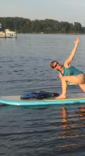 Robin Puett on a boat doing Yoga
