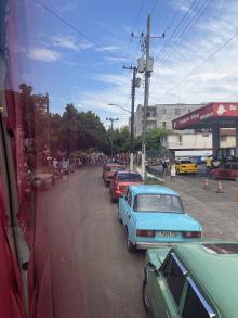A line of Cuban cars and drivers, waiting to buy gas.