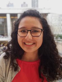 Long curly haired woman wearing glasses smiling 