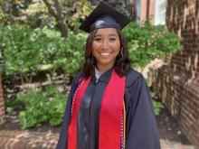 Mya in her graduate gown smiling to camera