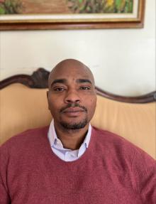 Man looking at camera with burgundy sweater