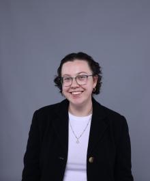 Shayna in suit coat smiling at camera