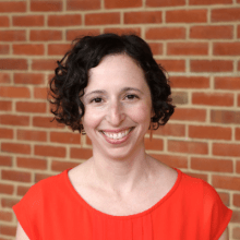 woman with short brown hair in a light colored business top