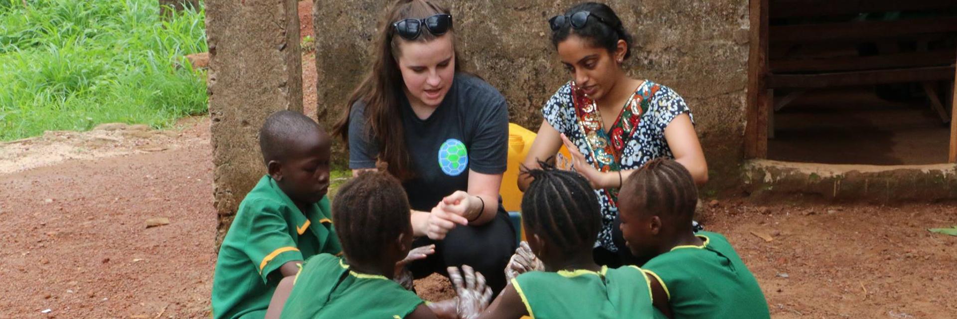 UMD students demonstrate handwashing technique with school kids in Sierra Leone