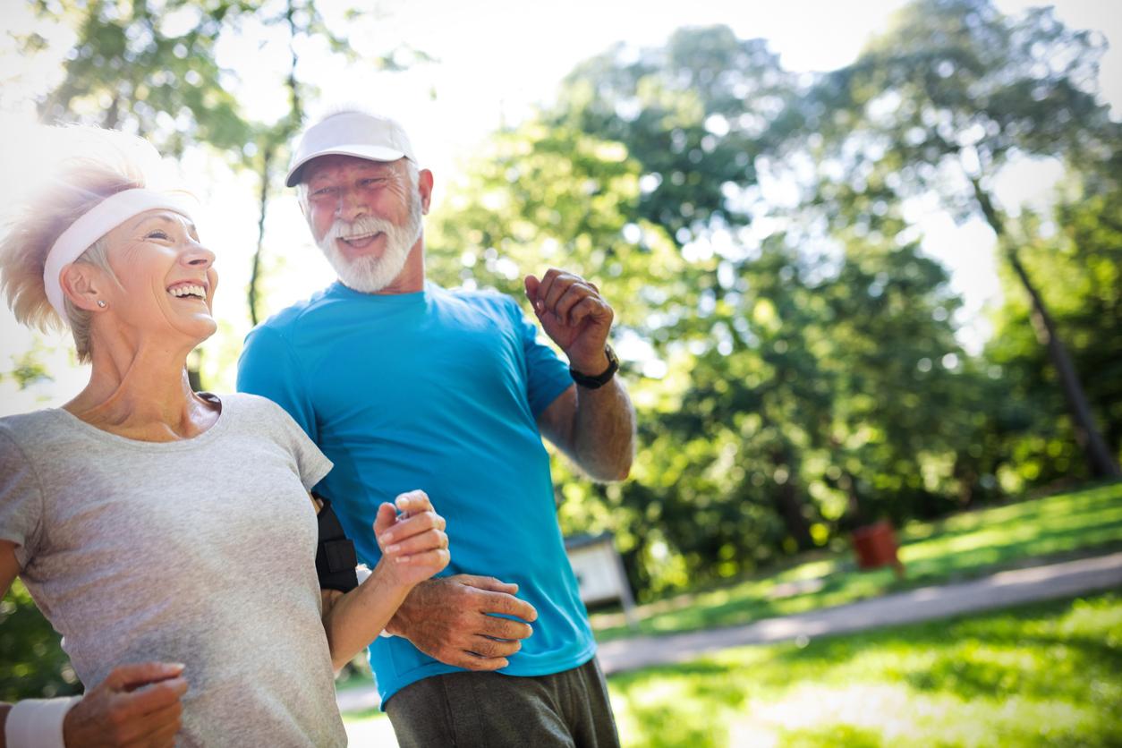 Older white couple running outside and smiling