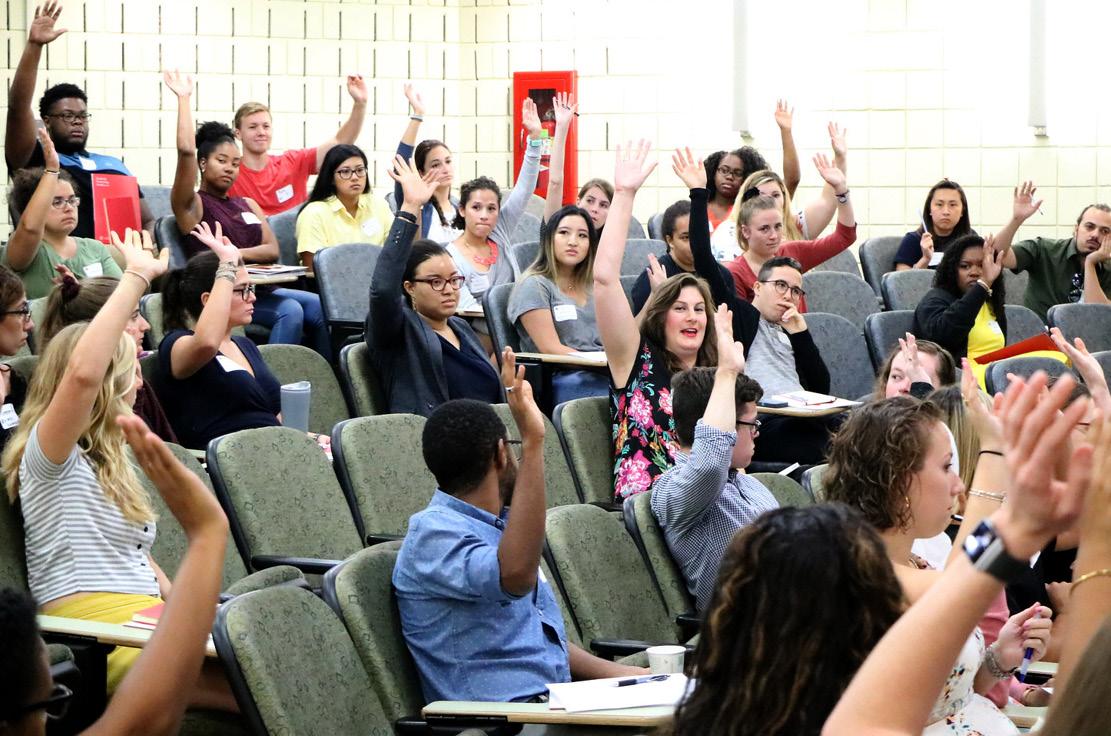 Students raising their hands asking questions in the SPH Lecture Hall at the University of Maryland