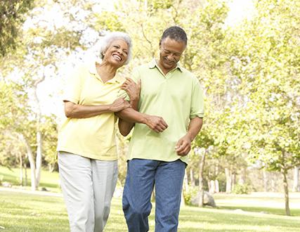 Happy older couple walking in the park in a sunny day 