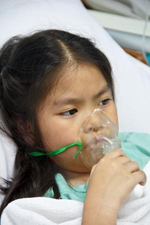 Kid using an oxygen mask in a hospital