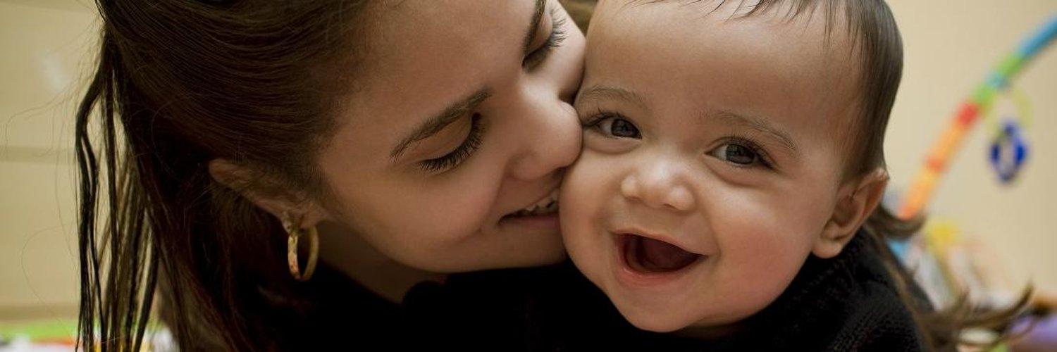 Mother kissing her baby on the cheek 