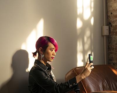 A non-binary femme using their phone
