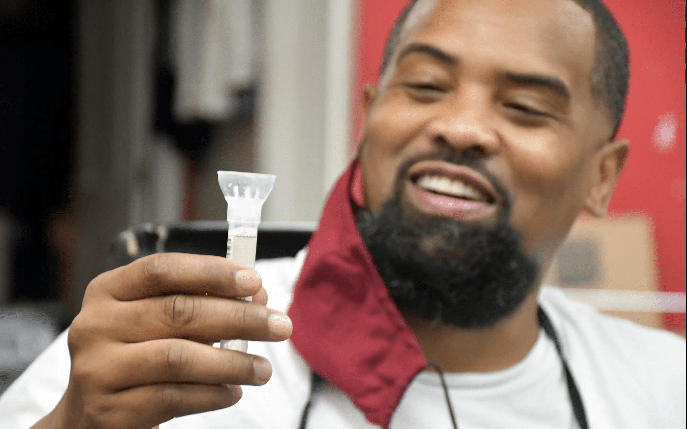 Man in barbershop holding testing specimen