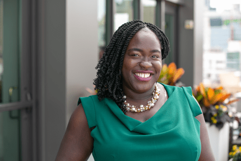 Black woman wearing a pearl necklace and green dress