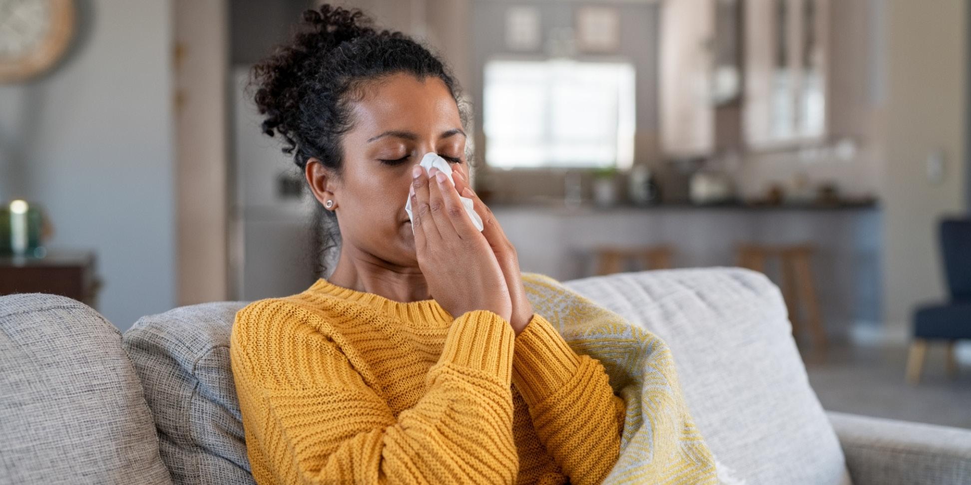 Sick woman blows her nose