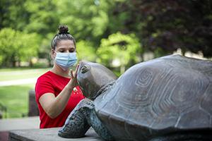 A University of Maryland Student touches Testudo's face