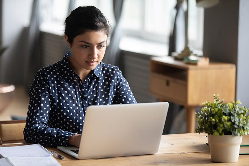 Young woman at desk on her laptop