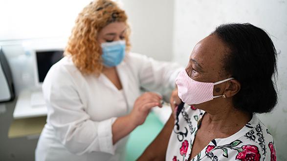 Woman receiving shot from health care worker