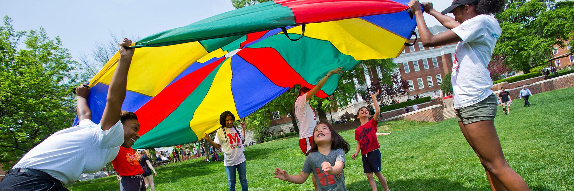 Maryland Day at UMD, kids and students playing parachute games.
