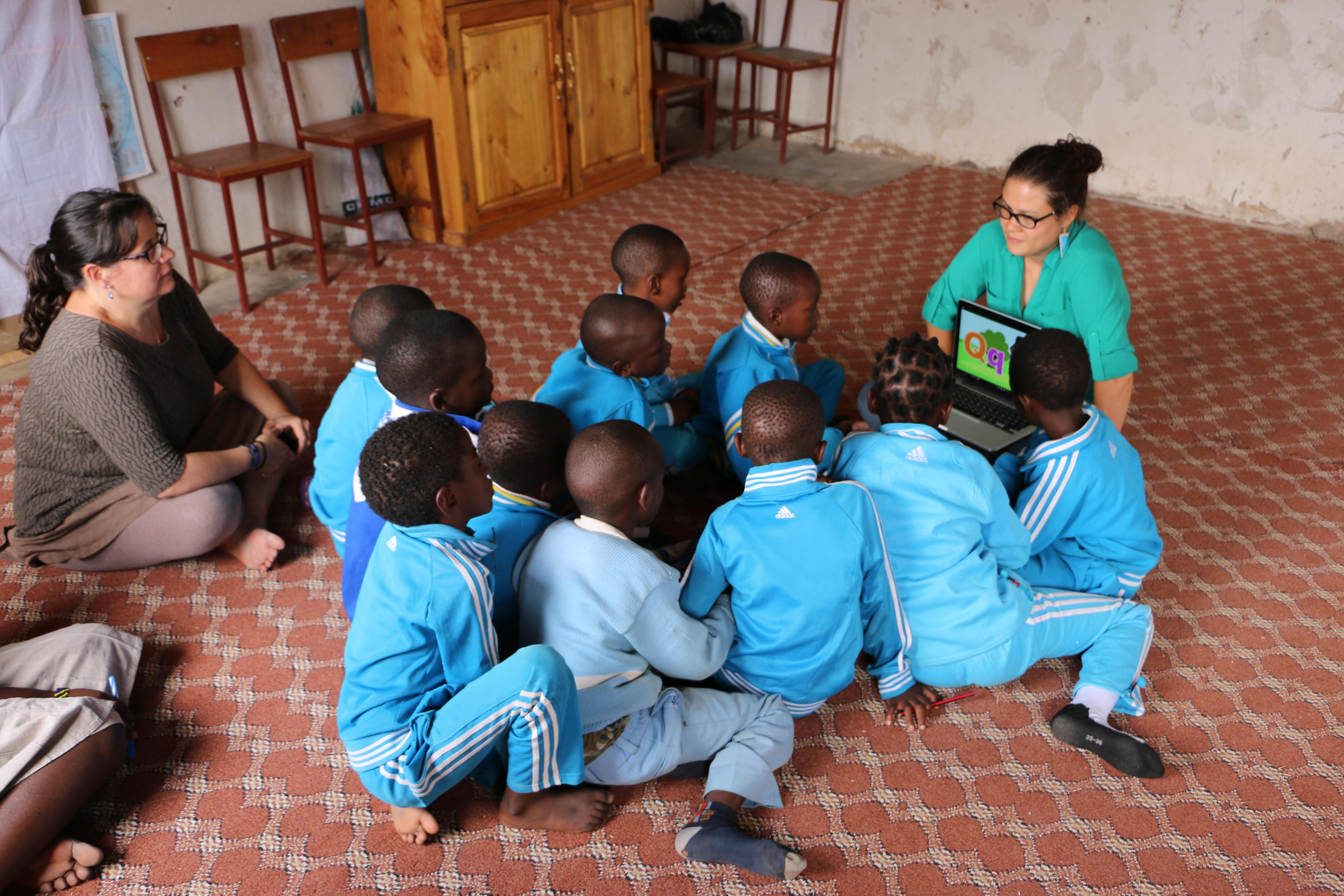 Akili and Dina Borzekowski with African students looking at a laptop 