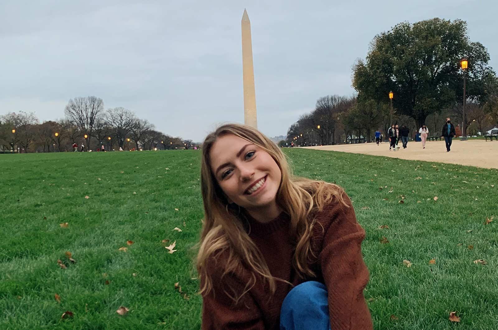 Students from the University of Maryland sits on National Mall with Washington Monument in background
