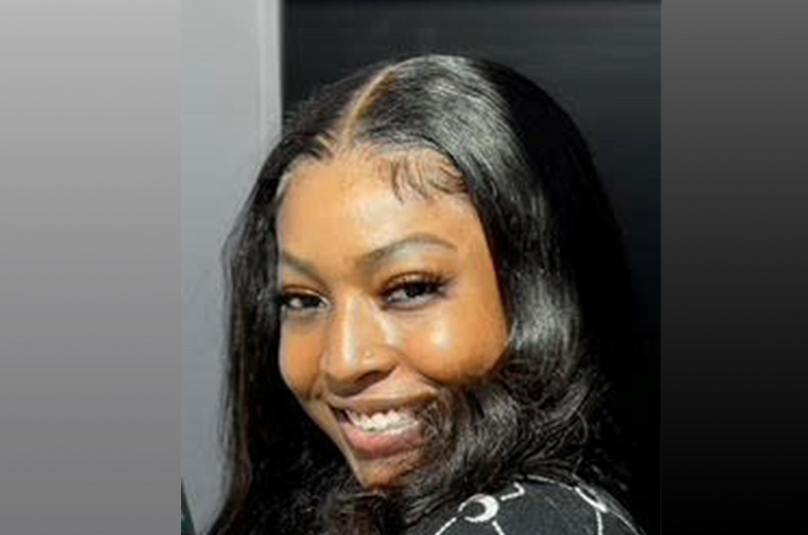 Student from the University of Maryland smiles at camera with gray and black background