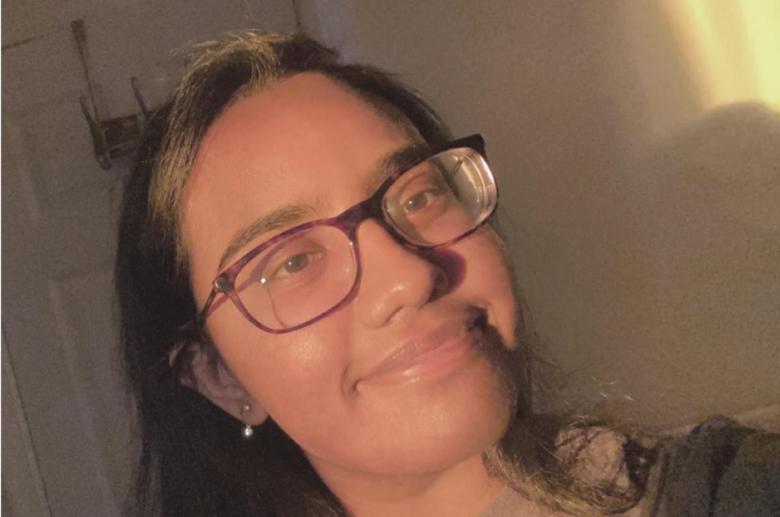 Student from the University of Maryland wearing glasses smiles at camera in selfi
