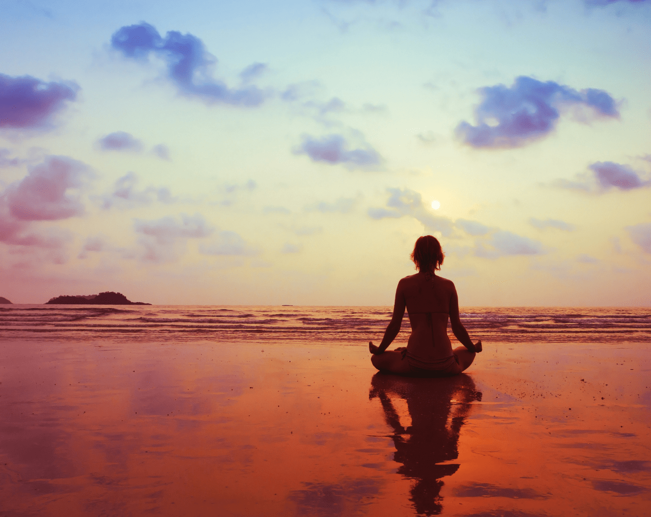 Person meditating on the beach