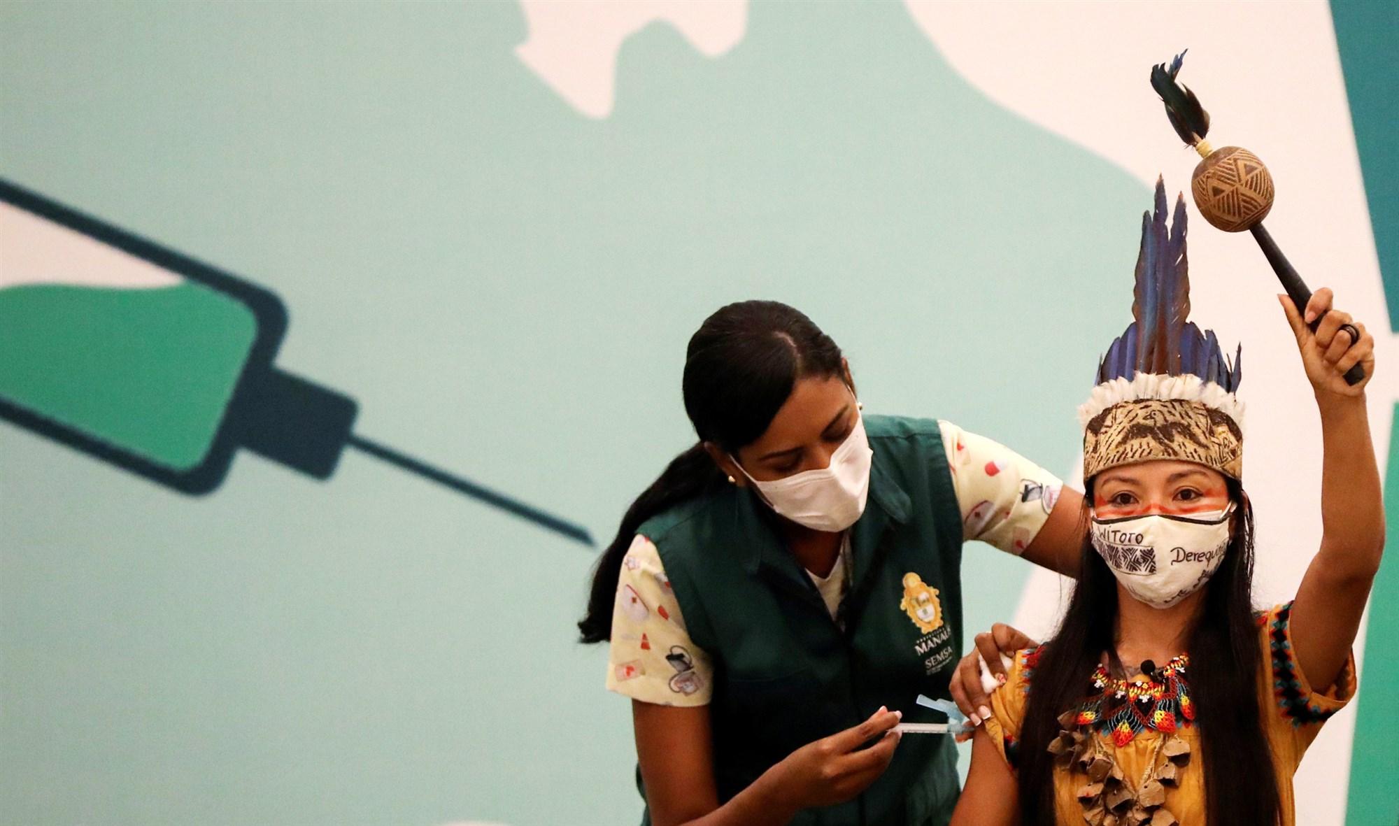 Vanderlecia Ortega dos Santos, or Vanda, from the Witoto indigenous tribe, receives a Covid-19 vaccine in Manaus, Brazil, on Jan. 18, 2021. Bruno Kelly / Reuters