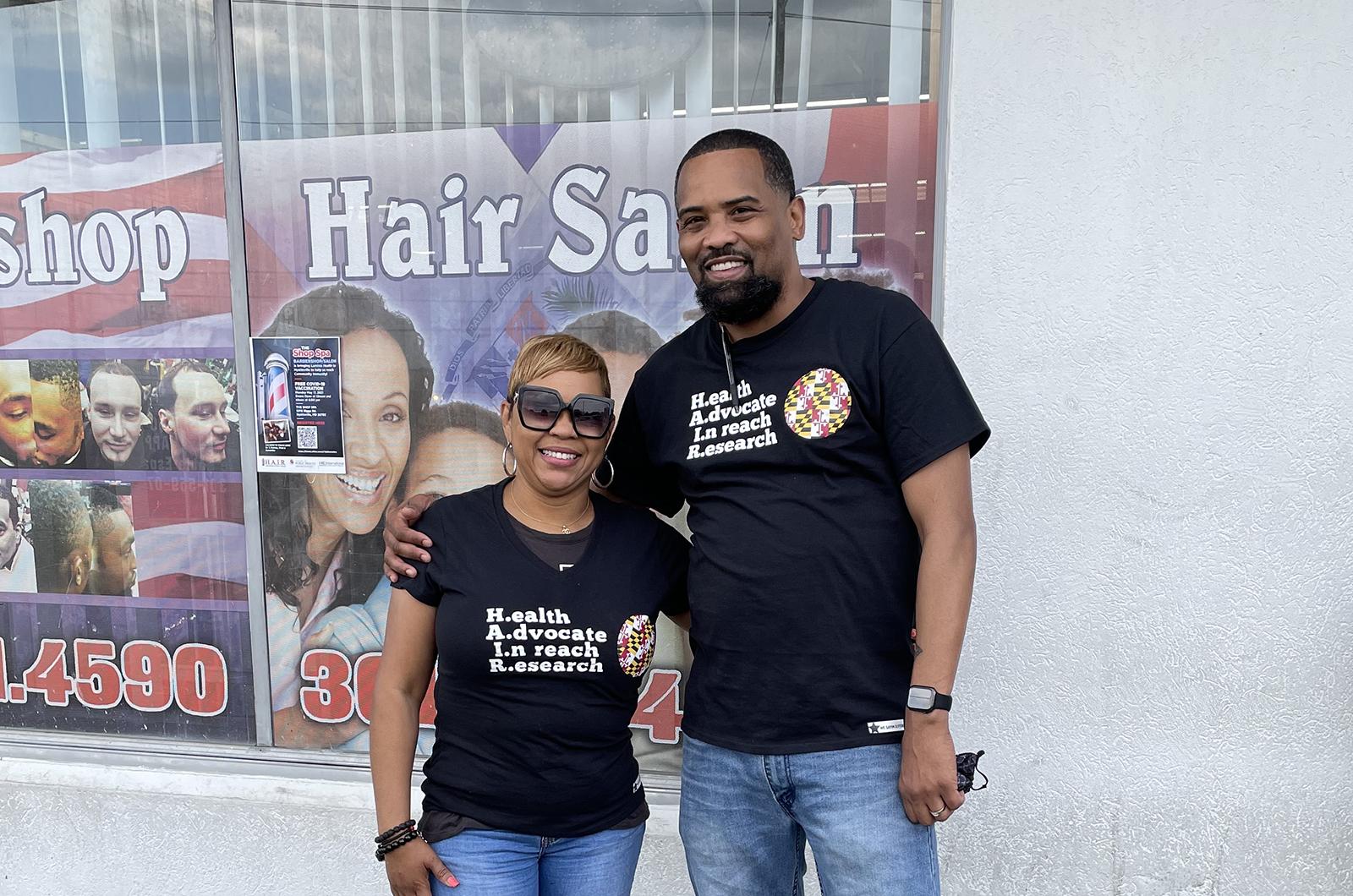 Hair stylist Katrina Randolph and barber Mike Brown wearing their Health Advocates InReach and Research shirts