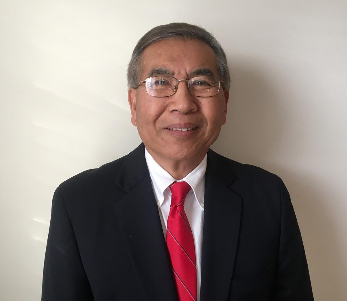 Ching-Tzone Tien wearing glasses, white shirt, red tie and black suit.