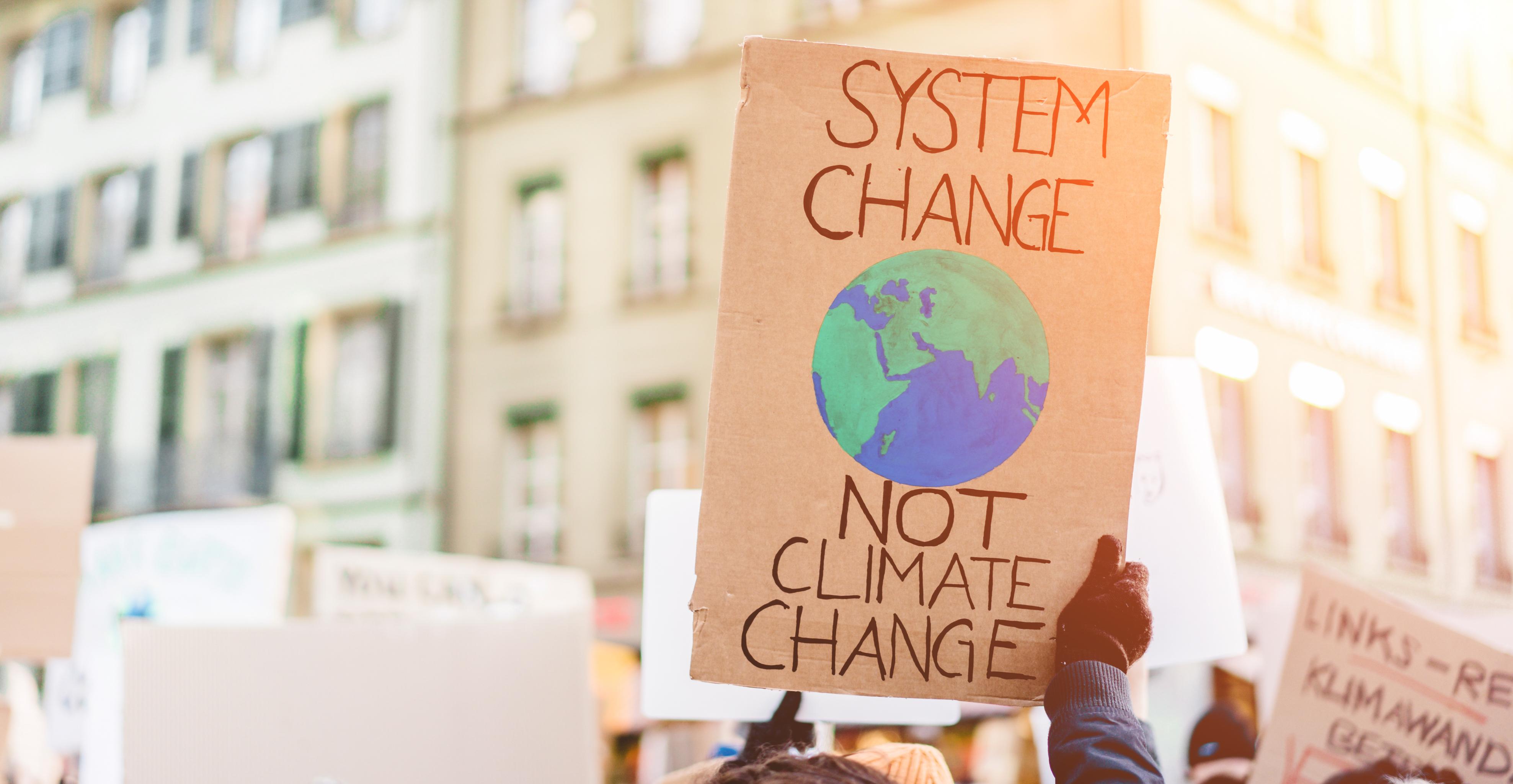 Protest sign reading system change not climate change