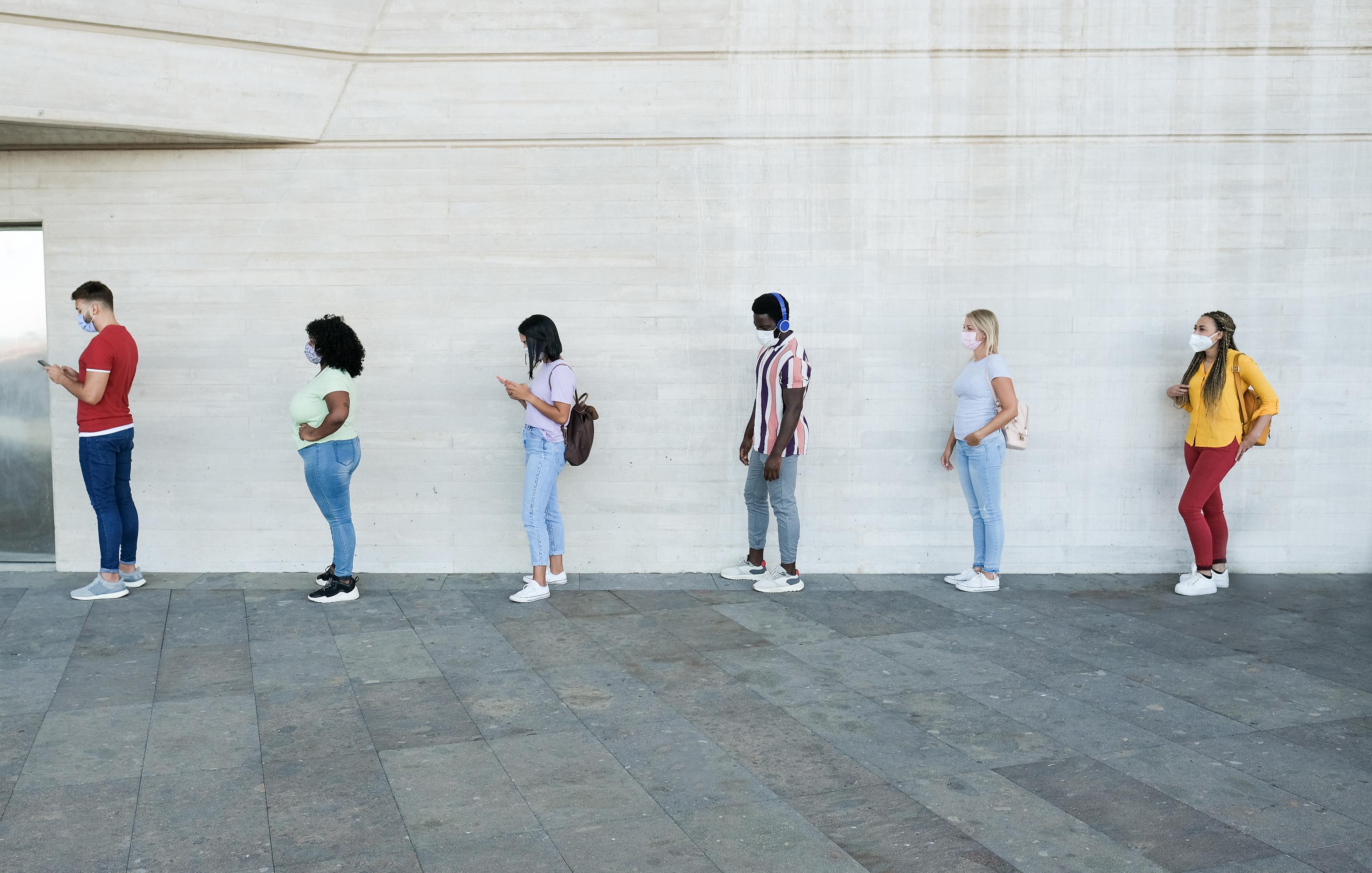 Young people with social distancing and wearing protective face masks 