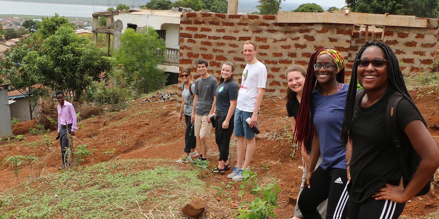 Diverse group of UMD students standing outside in a community in Sierra Leone