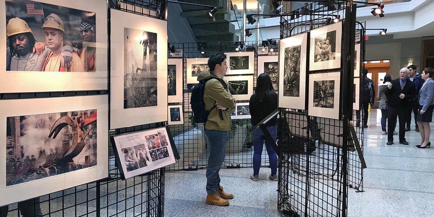 People browse a photographic exhibit of images taken by Earl Dotter who chronicles the struggles of American workers
