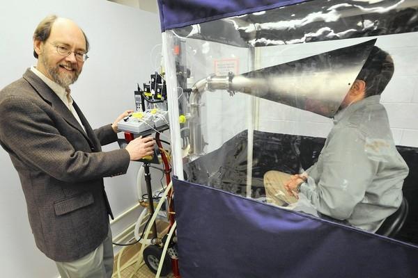 Dr. Donald Milton (left) and a study participant in the Gesundheit II machine, which is used to capture and analyze influenza virus in exhaled breath.