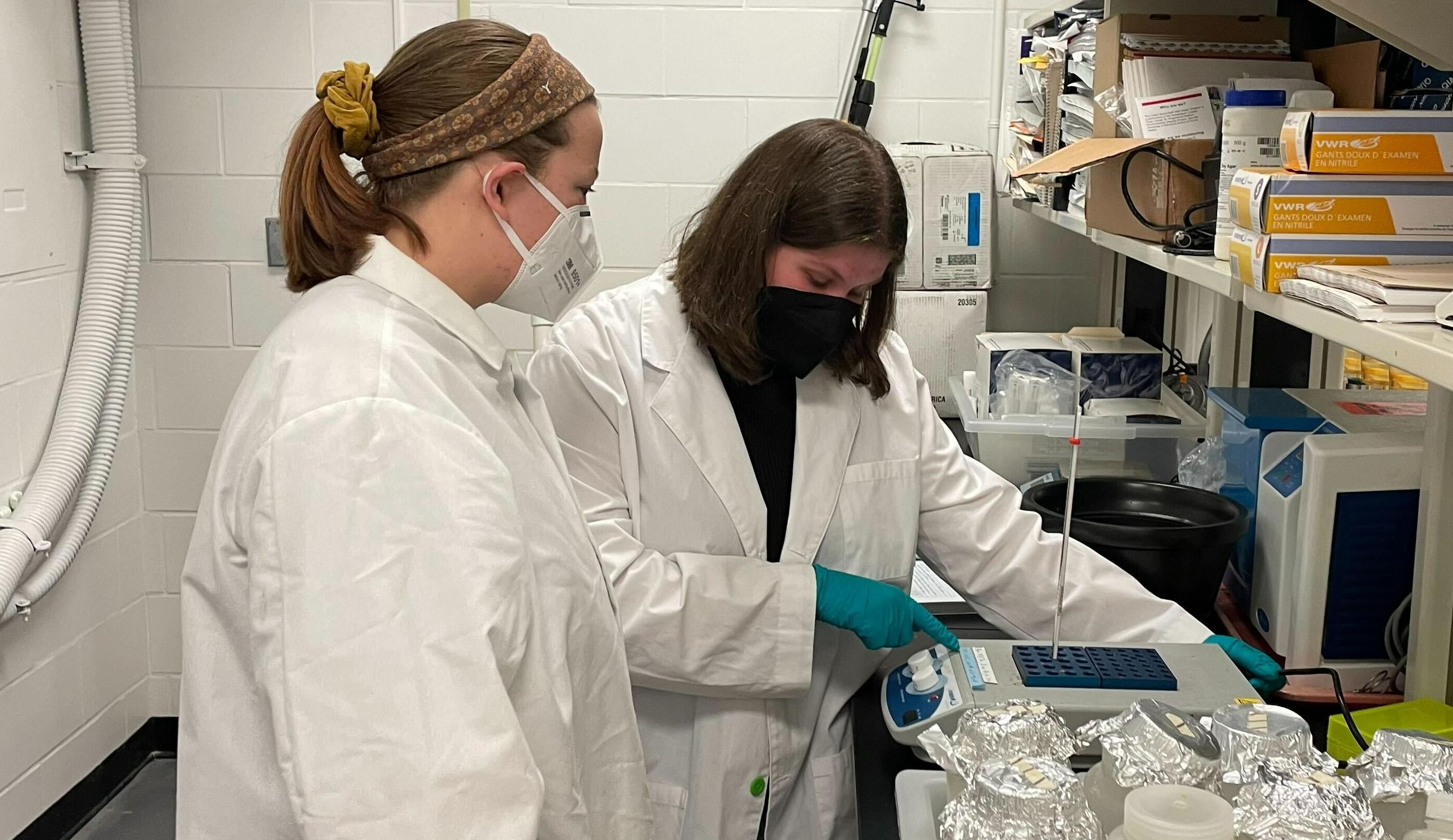 Mya and Emily monitor the heating plate during DNA extraction.