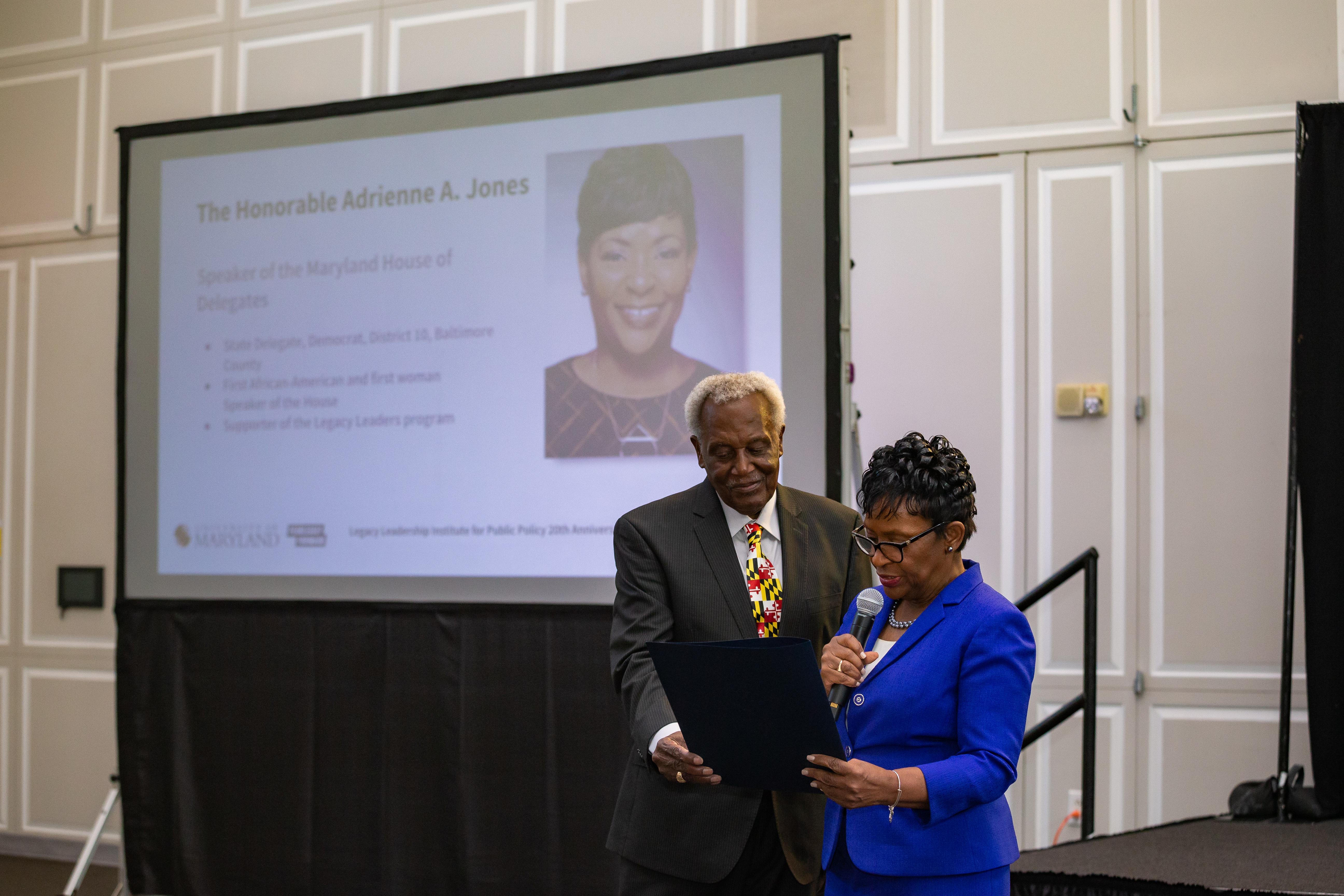 Wesley Queen and Del. Adrienne A. Jones, speaker of the Maryland House of Delegates, review a citation commemorating the LLIPP.