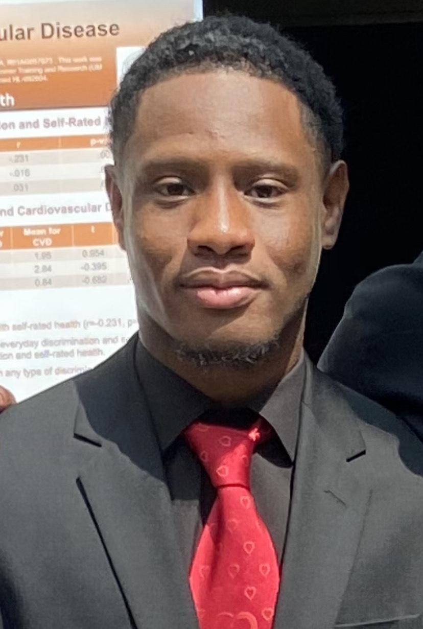 School of Public Health student is wearing a black suit with a red tie.