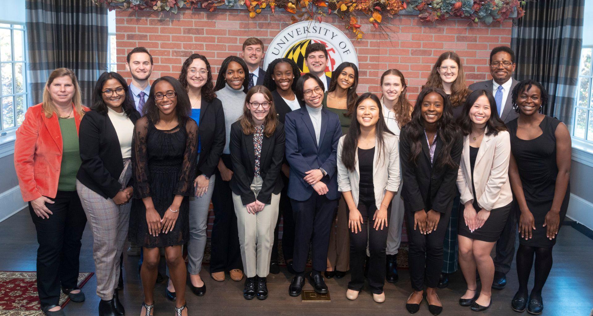 Group of college students who are also Merrill Scholars standing in front of University of Maryland seal.