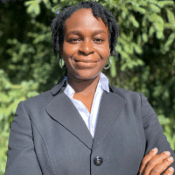 Deborah Omotoso, a young woman wearing a grey blazer and blue collared short.